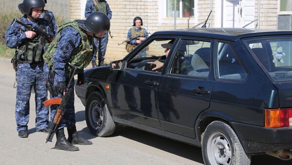 Сотрудники полиции досматривают автомобиль на месте проведения контртеррористической операции - Sputnik Южная Осетия