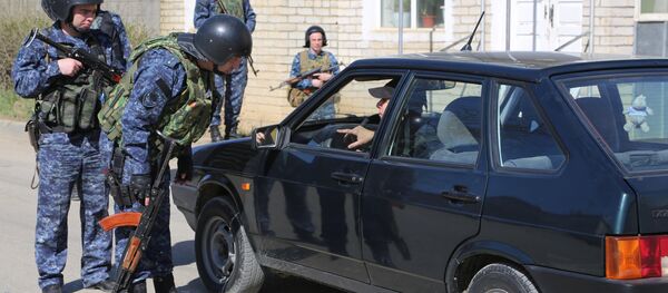Сотрудники полиции досматривают автомобиль на месте проведения контртеррористической операции Сотрудники полиции досматривают автомобиль на месте проведения контртеррористической операции - Sputnik Южная Осетия