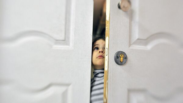 Девочка заглядывает в приоткрытую дверь социального отделения городской детской больницы - Sputnik Хуссар Ирыстон
