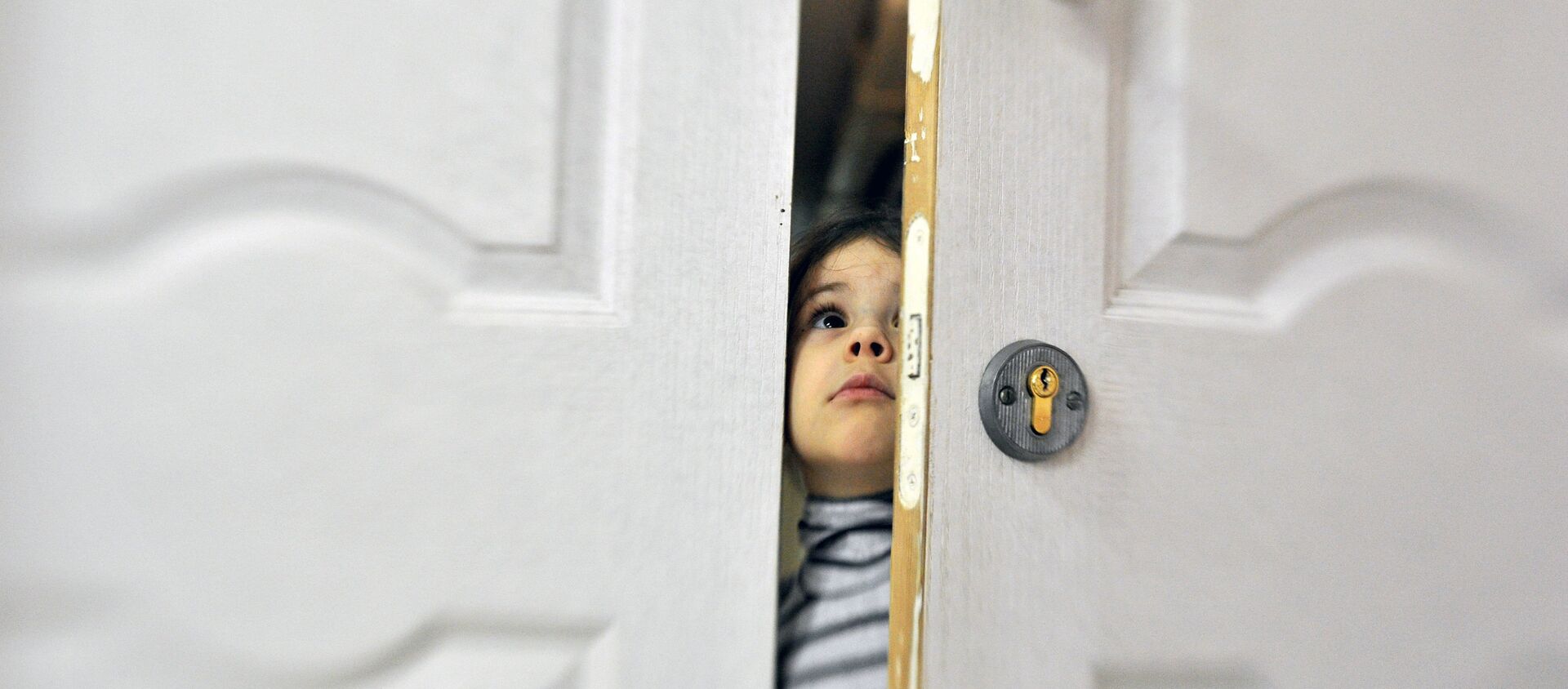 Девочка заглядывает в приоткрытую дверь социального отделения городской детской больницы - Sputnik Южная Осетия, 1920, 03.06.2021