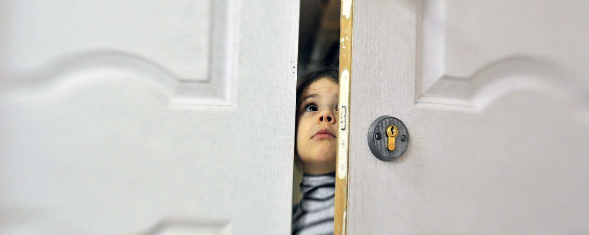 Девочка заглядывает в приоткрытую дверь социального отделения городской детской больницы - Sputnik Южная Осетия, 1920, 03.06.2021