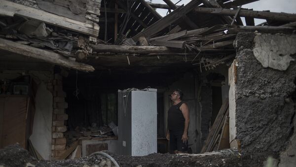 Местный житель в своем доме, разрушенном в результате обстрела - Sputnik Южная Осетия