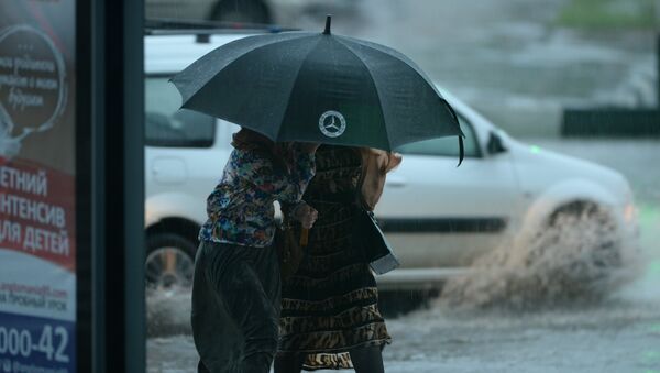 Женщины идут под зонтом во время сильного дождя в Грозном - Sputnik Южная Осетия