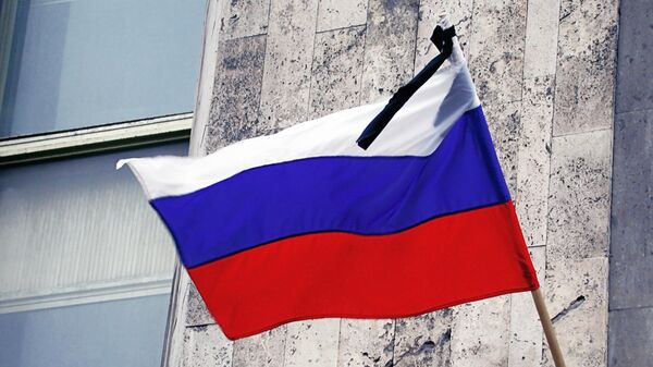 Траурная лента на флаге РФ в день траура по погибшим во время теракта в Театральном центре на Дубровке - Sputnik Южная Осетия