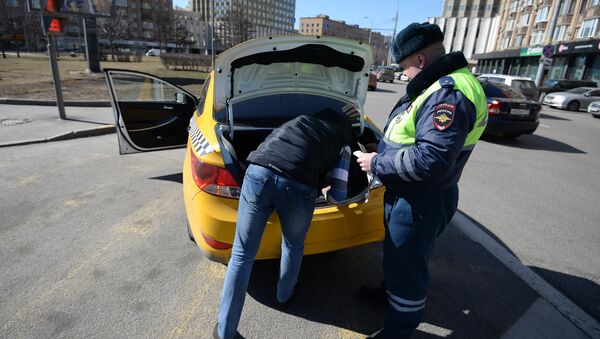 Сотрудник ГИБДД проверяет документы у таксиста - Sputnik Южная Осетия