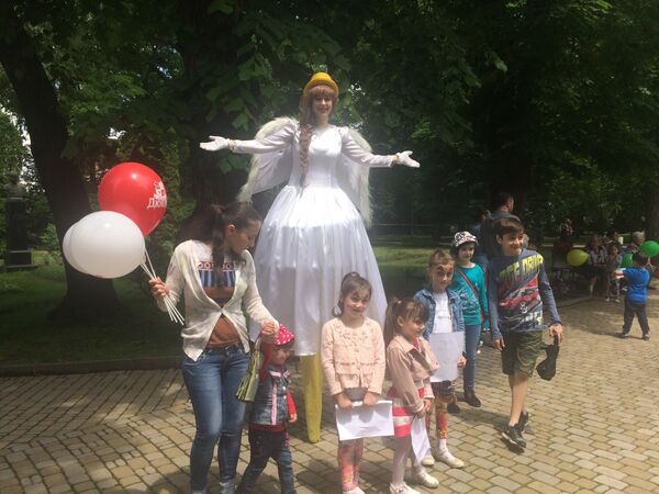В центральном парке гостей праздника встречала дама на ходулях - Sputnik Южная Осетия