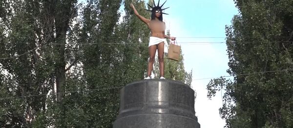 В Киеве активистка Femen бросалась конфетами Roshen с памятника Ленину В Киеве активистка Femen бросалась конфетами Roshen с памятника Ленину - Sputnik Южная Осетия
