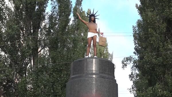 В Киеве активистка Femen бросалась конфетами Roshen с памятника Ленину - Sputnik Южная Осетия