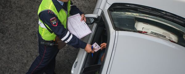 Сотрудник ГИБДД проверяет документы Сотрудник ГИБДД проверяет документы - Sputnik Южная Осетия