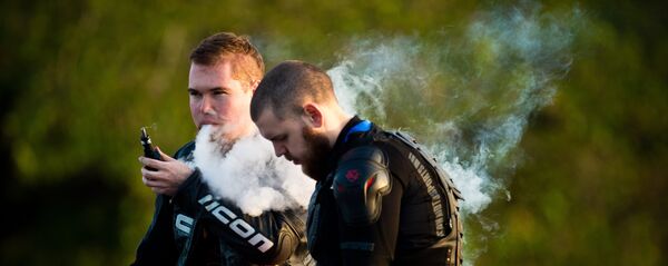 Молодые люди курят электронные сигареты Молодые люди курят электронные сигареты - Sputnik Южная Осетия