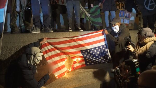 Активисты Anonymous сожгли флаг США на Марше миллиона масок в Лондоне - Sputnik Южная Осетия