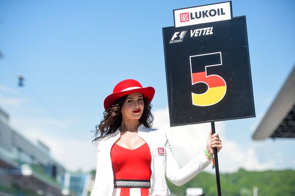 Девушка держит табличку с номером места гонщика на трассе перед гонкой на российском этапе чемпионата мира по кольцевым автогонкам в классе Формула-1 - Sputnik Южная Осетия
