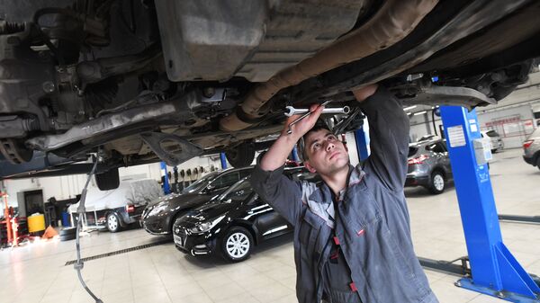 Сотрудник сервисного центра осматривает автомобиль - Sputnik Южная Осетия