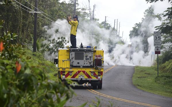 Пожарный во время фотографирования дыма над расщелиной на Гавайях - Sputnik Южная Осетия