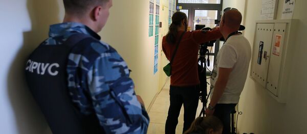 Охранник предприятия Сириус и журналисты у офиса РИА Новости Украина в Киеве, где СБУ проводит обыски Охранник предприятия Сириус и журналисты у офиса РИА Новости Украина в Киеве, где СБУ проводит обыски - Sputnik Южная Осетия