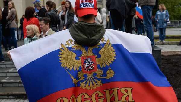 Участник праздничного митинга в честь Дня России на площади Ленина в Новосибирске - Sputnik Южная Осетия