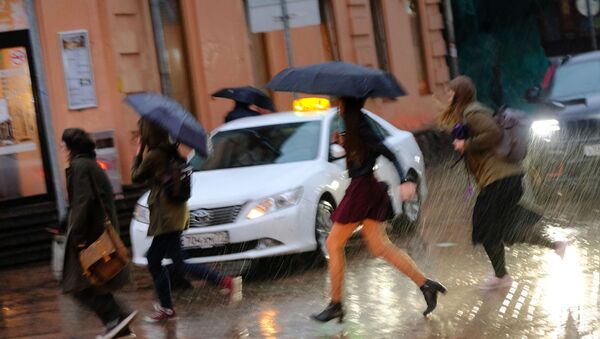 Пешеходы на улице во время сильного дождя - Sputnik Южная Осетия