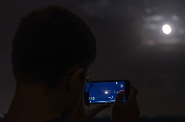 Мужчина снимает на телефон луну во время полного затмения из обсерватории Кубанского Государственного университета - Sputnik Южная Осетия