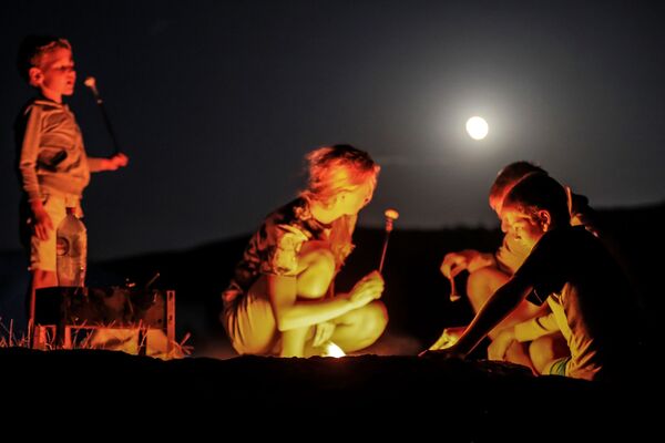 Туристы во время полного лунного затмения над мысом Меганом в Крыму - Sputnik Южная Осетия