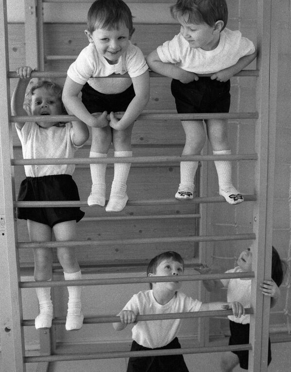 Дети в детском саду занимаются физкультурой на шведской стенке, 1985 год - Sputnik Южная Осетия