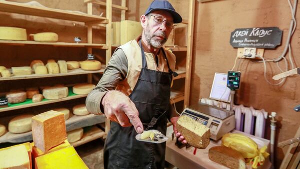 Фермер Джей Роберт Клоуз нарезает сыр в магазине при ферме в Московской области, деревни Мошницы - Sputnik Южная Осетия