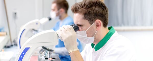 Молодые ученые работают с микроскопом в лаборатории - Sputnik Южная Осетия