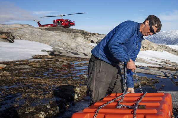 Сотрудник службы безопасности собирает оборудование для работы в научном лагере на леднике Хелхейм в Гренландии - Sputnik Южная Осетия