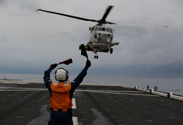 Акико Ихара из экипажа женской летной палубы руководит высадкой вертолета SH-60K Sea Hawk на палубе в Индийском океане, Индонезия, 24 сентября 2018 года. Мы иногда немного жалуемся на наших коллег-мужчин, — признается она. — Но очень хотим, чтобы женщины работали в самых разных сферах - Sputnik Южная Осетия