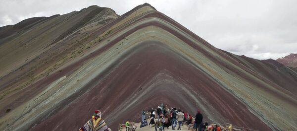 Коренной житель Анд с ламой и туристы напротив горы Виникунка в Перу - Sputnik Южная Осетия