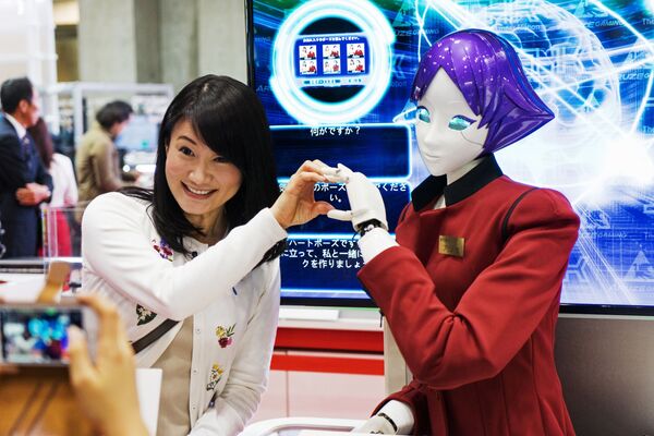 Посетительница фотографируется с роботом FASHION Junko Koshino на международной выставке роботов IREX в Токио - Sputnik Южная Осетия