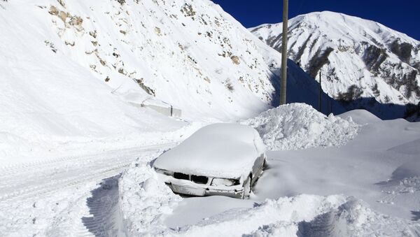 Заваленный снегом автомобиль на обочине автомобильной дороги Транскавказской магистрали в Северной Осетии, перекрытой из-за схода снежных лавин - Sputnik Южная Осетия