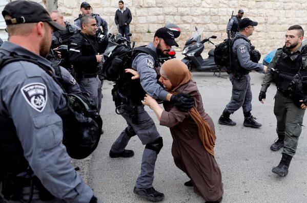 Палестинка пытается прорваться сквозь заслон израильских полицейских после того, как израильские власти закрыли вход на Храмовую гору в Иерусалиме - Sputnik Южная Осетия