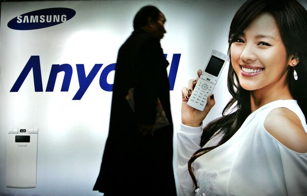 Пешеход идет мимо рекламного щита Samsung Mobile в Сеуле, Южная Корея. 2007 год - Sputnik Южная Осетия