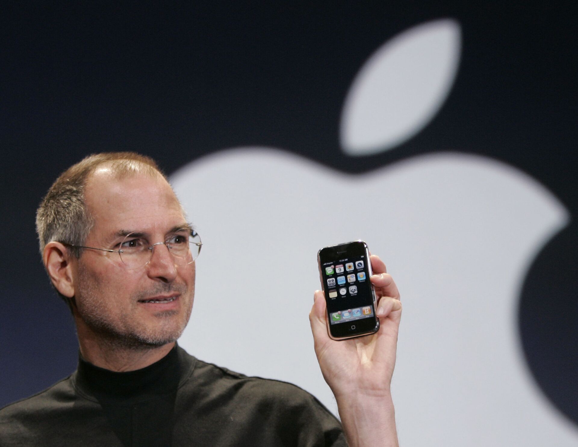 CEO корпорации Apple Стив Джобс держит Iphone на конференции MacWorld в Сан-Франциско, 2007 год - Sputnik Южная Осетия, 1920, 23.02.2022