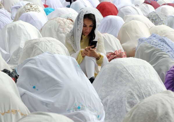 Мусульманка с мобильным телефоном среди молящихся во время празднования Ид аль-адха в Джакарте - Sputnik Южная Осетия