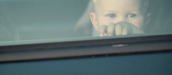 Маленький ребенок смотрит в окно автомобиля Маленький ребенок смотрит в окно автомобиля - Sputnik Южная Осетия