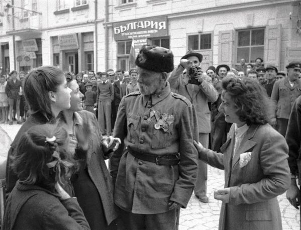 Ветеран турецкой войны беседует с девушками, в освобожденном войсками РККА от фашистов, болгарском городе, 1944 год - Sputnik Южная Осетия