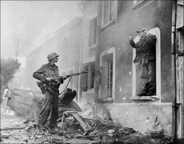 Американский солдат держит на прицеле немецкого солдата во время освобождения Франции в ходе Второй Мировой войны, 1944 год - Sputnik Южная Осетия
