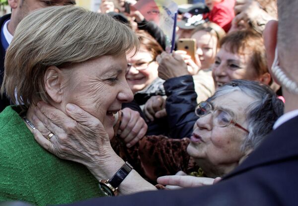 Канцлер Германии Ангела Меркель рядом с приветствующими ее жителями румынского города Сибиу - Sputnik Южная Осетия