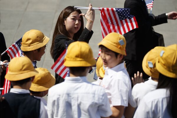 Японские школьники с американскими флагами готовятся к приезду президента США Дональда Трампа в Императорский дворец в Токио - Sputnik Южная Осетия