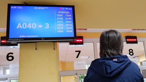 Посетитель у табло электронной очереди в отделении ГИБДД - Sputnik Южная Осетия