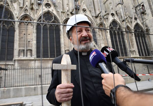 Священнослужитель дает интервью журналистам перед участием в мессе в соборе Парижской Богоматери - Sputnik Южная Осетия