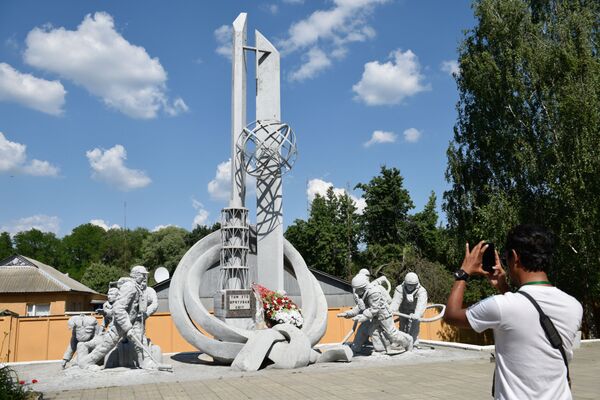 Туристы фотографируют монумент пожарным Тем, кто спас мир во время экскурсии в зону отчуждения ЧАЭС - Sputnik Южная Осетия
