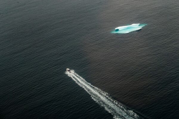 Катер проходит мимо айсберга в открытом океане возле Тасиилака, Гренландия - Sputnik Южная Осетия