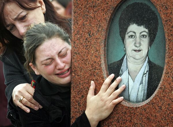 Дочь Анны Дзгоевой возле могилы матери. Сентябрь 2005 год. - Sputnik Южная Осетия