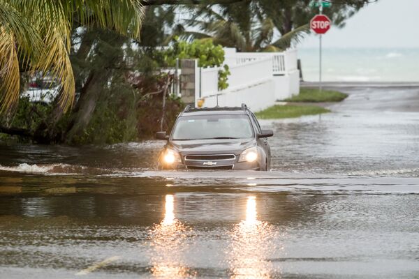 Автомобиль проезжает по затопленной в результате урагана Дориан улице в Нассау, Багамы - Sputnik Южная Осетия