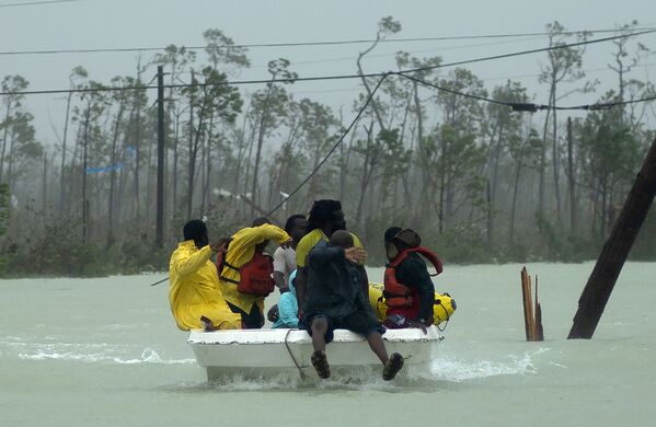 Добровольцы на лодке спасают семью от вызванного ураганом Дориан наводнения во Фрипорте - Sputnik Южная Осетия