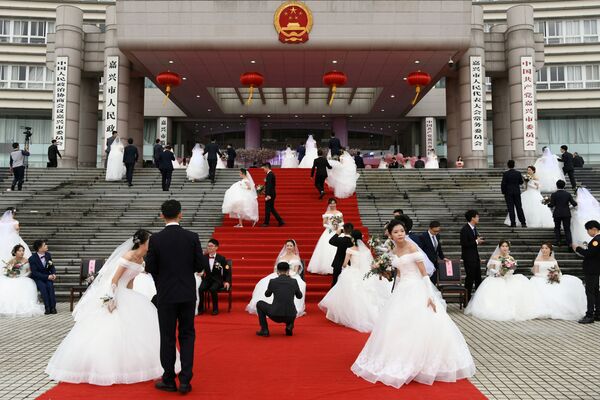 Молодожены на массовой свадьбе у здания городского правительства в преддверии 70-летия КНР - Sputnik Южная Осетия