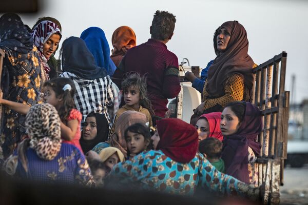 Сирийские арабские и курдские мирные жители бегут от турецких бомбардировок сирийского города Рас-эль-Айн на границе с Турцией - Sputnik Южная Осетия