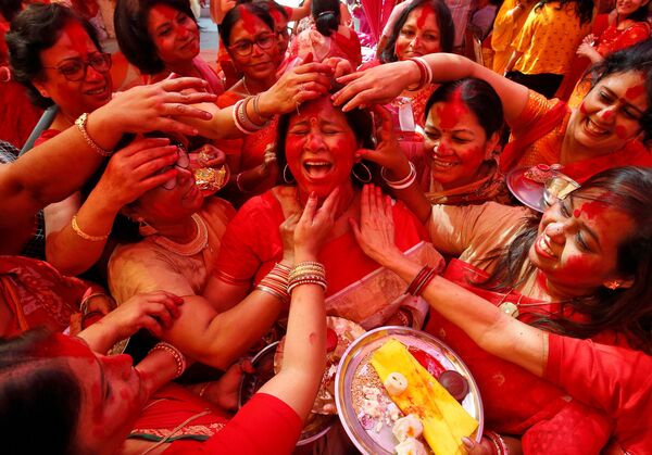 Нанесение цветного порошка на лицо индийской женщины в честь поклонения индуистской богине Дурги на фестивале Durga Puja в Чандигархе, Индия - Sputnik Южная Осетия